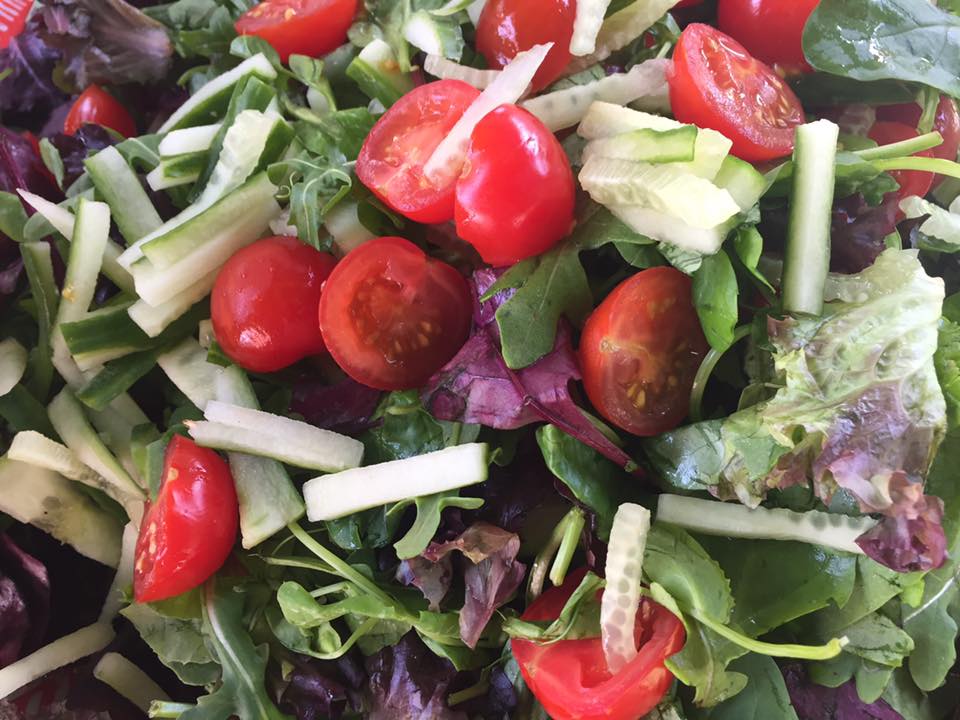 Tomatoes and lettuce in a fresh salad made by FirstBite Community Food Project.