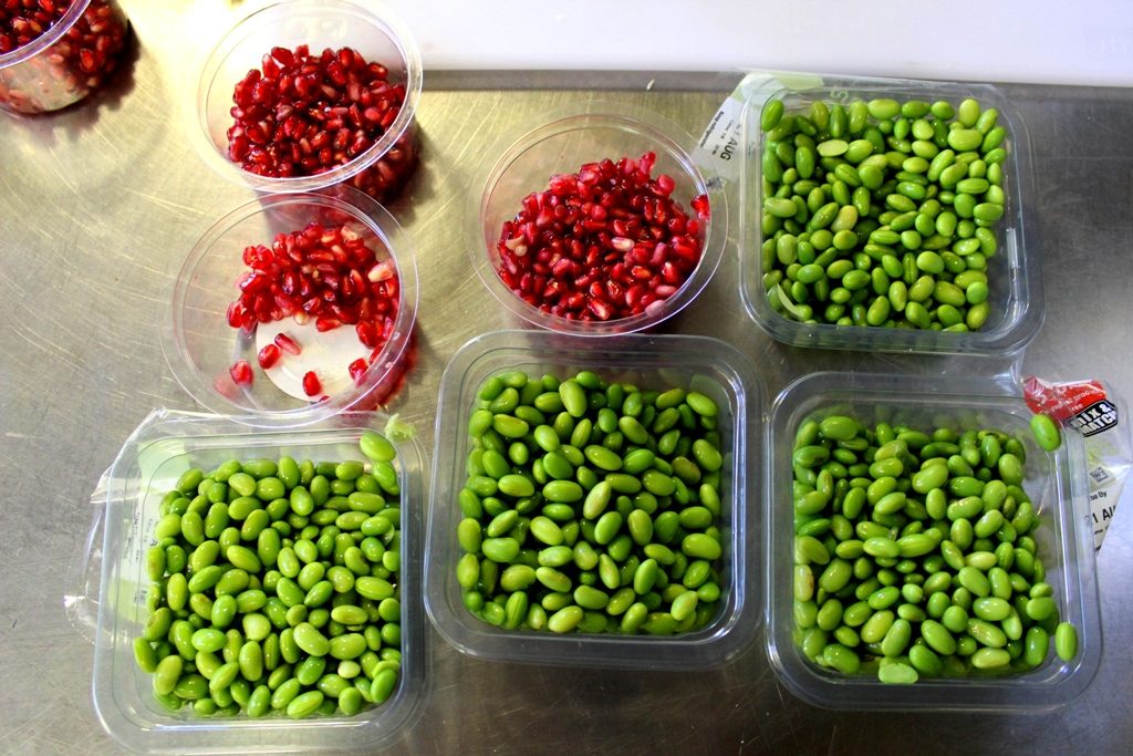 Smalls packets of edamame beans and pomegranate seeds