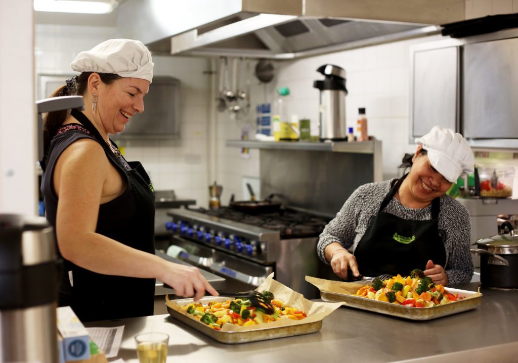 MaMay0080973. The Daily Telegraph. Fely, a service user (right) and Tanya, an ex-service user (left), are seen preparing food in the kitchen of The Marylebone Project, a women's refuge, in Marylebone, London, which benefits from the charity Fare Share. Excess food from supermarkets is distributed by the charity Fare Share to needy people such as the service users of the Marylebone Project, many of whom are vulnerable and homeless women. Fare Share is the UK's largest charity fighting hunger and food waste, and is one of this year's Telegraph Christmas Charity Appeal chosen charities. Tuesday January 16, 2018.