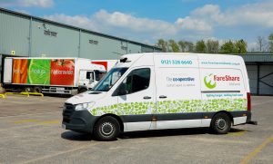 Nationwide lorry delivering food to FareShare warehouse with FareShare van in foreground