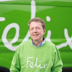 Headshot of Gavin Darby wearing green jumper with Felix logo standing in front of Felix branded van