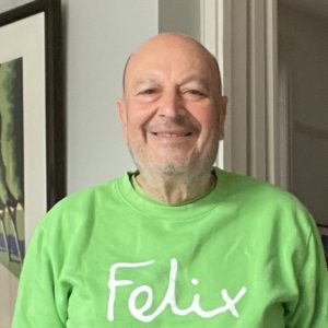 Headshot of Ben Salama smiling wearing a green jumper with the Felix logo