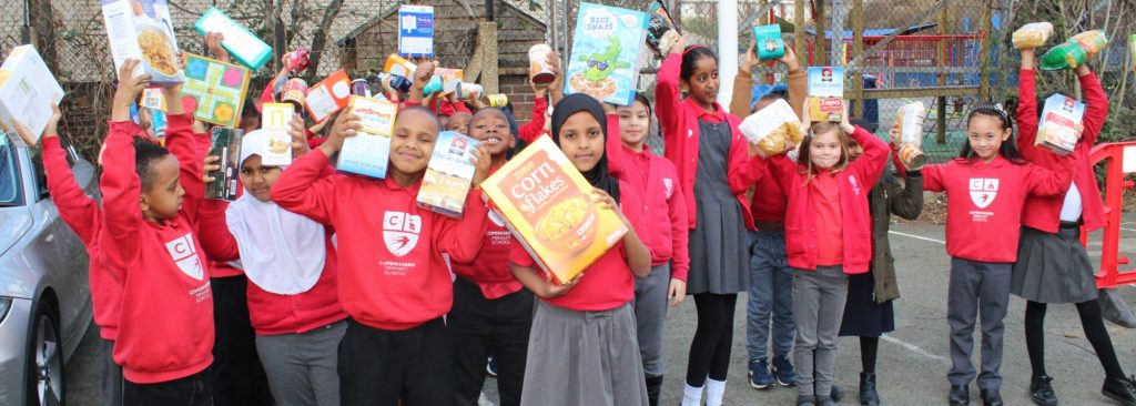 Group of lots of school children holding boxes of cereal