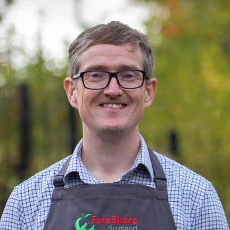 Jon Molyneux is FareShare's Scottish Affairs Lead. He is pictured here wearing an apron that says "FareShare Scotland"